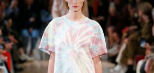 modelo exibe camiseta estampada com tye dye em desfile de moda