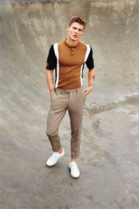 modelo exibe camisa polo masculina com calça de alfaiataria